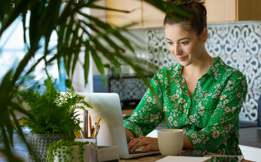 Das Bild zeigt eine Frau mit Laptop und Smartphone