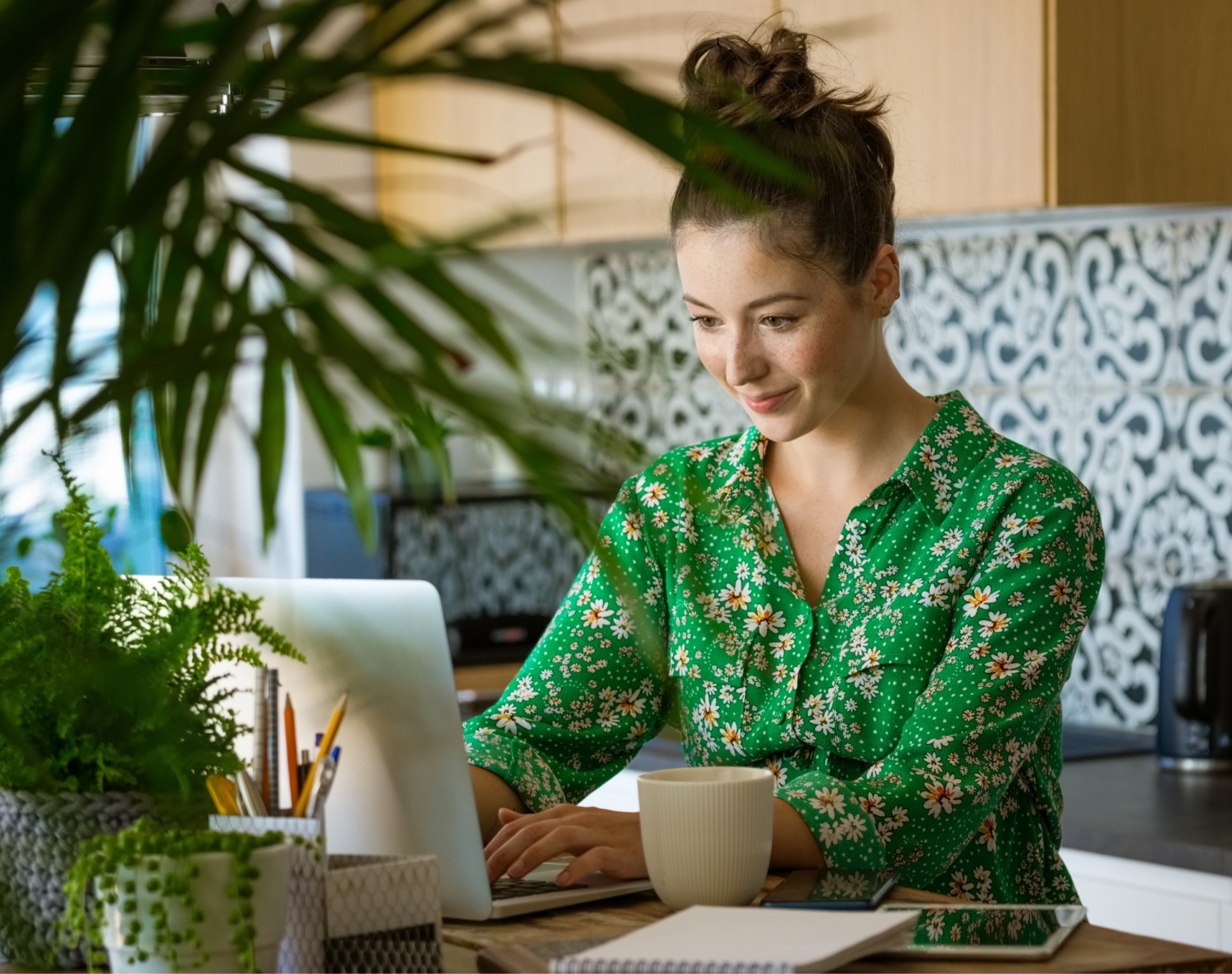 Das Bild zeigt eine Frau mit Laptop und Smartphone