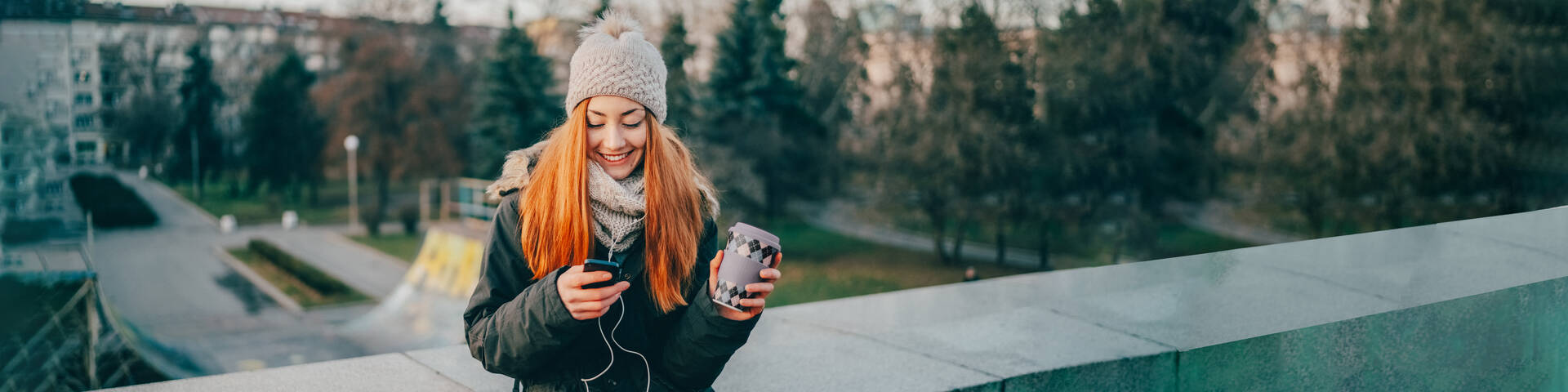 Frau im Winter-Outfit freut sich über ihren neuen Handytarif